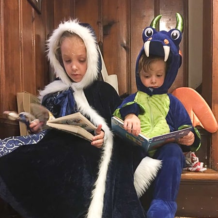 2 enfants sont déguisés pour jouer en lisant un livre et en créant leur propre histoire