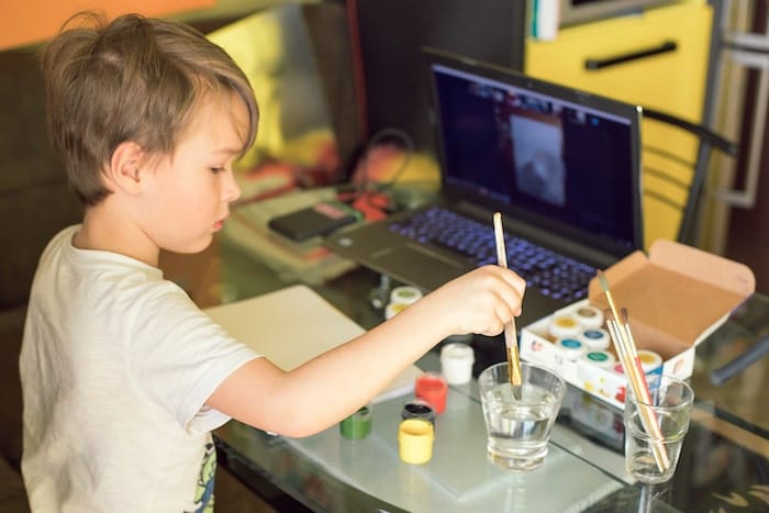 Un enfant fait de la peinture lors d'un atelier en ligne