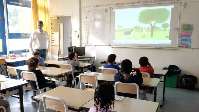 Des enfants de primaires regardent une histoire en anglais