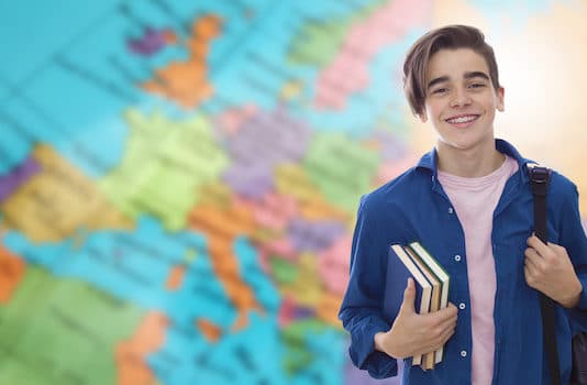 Un jeune devant une carte du monde se prépare pour un volontariat à l'étranger