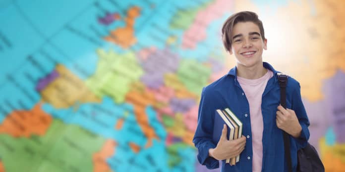 Contrats Volontariat Un jeune devant une carte du monde se prépare pour un volontariat à l'étranger