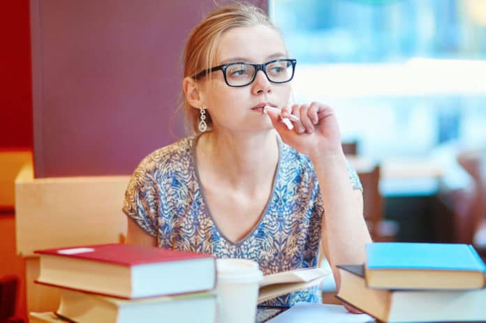 Examen IELTS Une jeune femme révise et prépare les tests pour réussir son examen IELTS