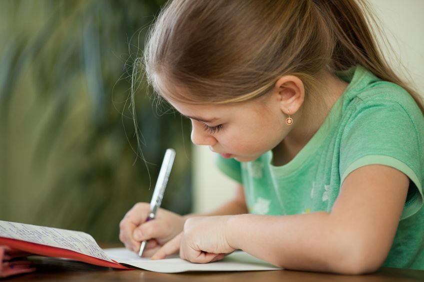 Une petite fille fait ses devoirs de CP du Cours Griffon