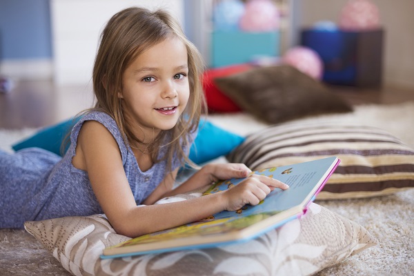 Une petite fille bilingue lit un livre en français