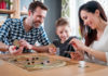Un enfant joue avec sa famille à un jeu de société pour apprendre l'anglais