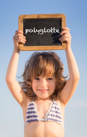 Petite fille tenant une ardoise scolaire indiquant polyglotte