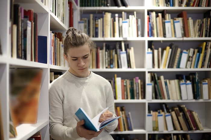 Un jeune découvre un livre dans une librairie internationale