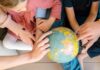 Une famille expatriée regarde un globe et s'interroge sur la scolarité à l'étranger